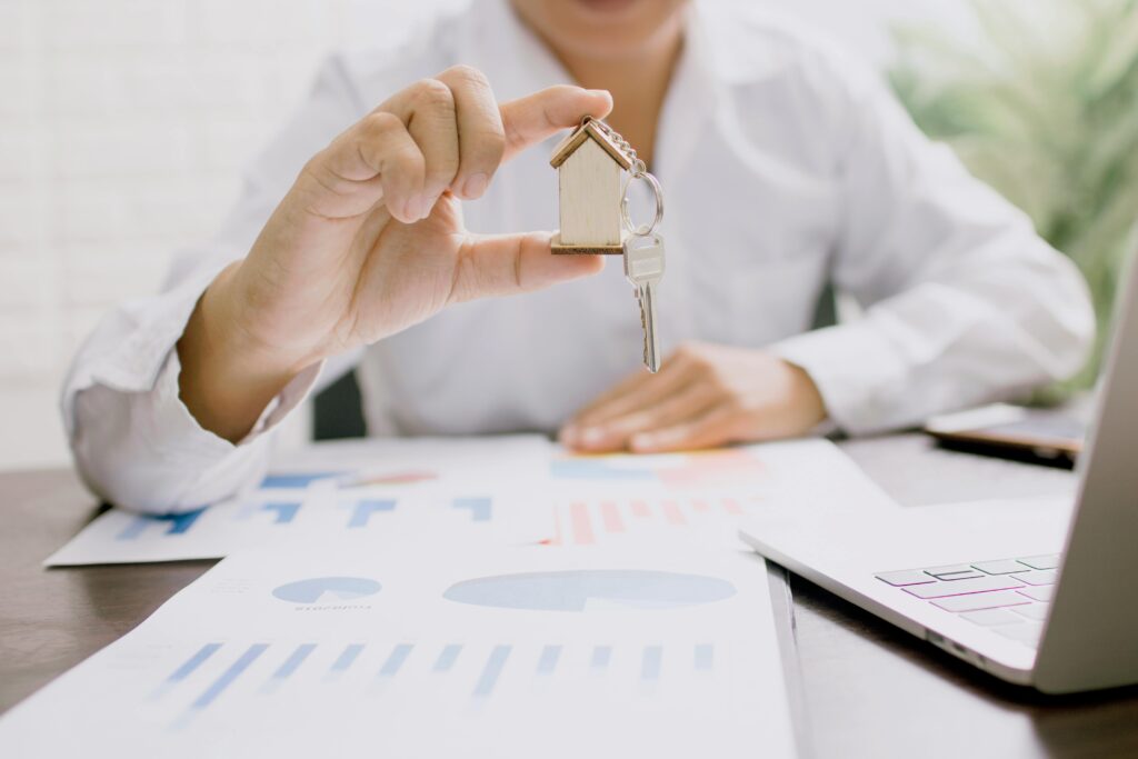 pexels-photo-4161619-4161619 Real estate professional presenting a house model with keys, symbolizing property investment and ownership.